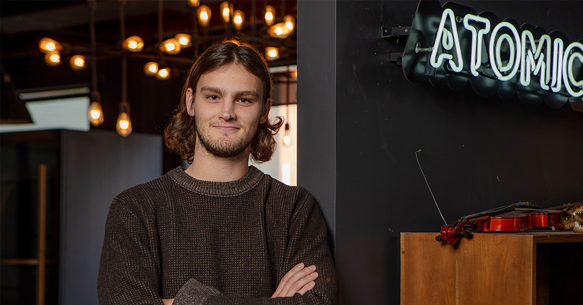 Sam Bessel leaning on Atomic 212° office wall